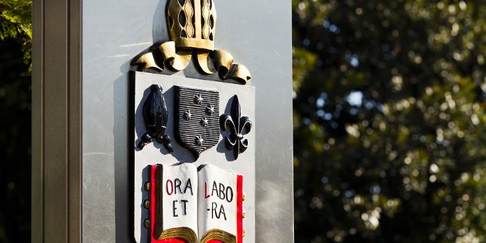 The shield of the school showing Ora et Labora